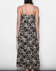 Woman wearing a black dress with beige pattern against a white background