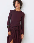 Woman wearing a burgundy dress with long sleeves against a white background front