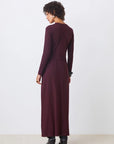 Woman wearing a long burgundy dress against a white background