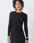 Woman wearing a black long-sleeve top with a draped design on a white background