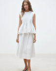 Luigi Sleeveless Pleat Top front view paired with white skirt
