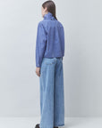 A model shown from the back wearing a blue and white checkered long-sleeve shirt and wide-leg light blue jeans, standing against a light gray studio background.