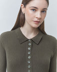 A woman wearing a ribbed knit polo-style top in olive green with a button-front placket, photographed against a light gray studio background.