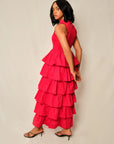 Woman wearing a red tiered dress against a plain background