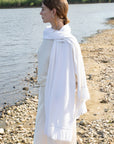 Woman wearing a white scarf by a body of water