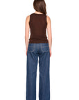 A woman shown from the back wearing a brown sleeveless top and wide-leg blue jeans against a plain white background.