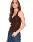 A woman modeling a brown ribbed knit tank top with a V-neck and button-down front, paired with blue jeans, against a plain white background.