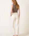 model wearing a bone colored utility jean / pant with a brown tank on a white background, back view