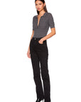 A woman modeling a short-sleeve gray knit polo-style top and black straight-leg jeans with black pointed-toe heels, photographed against a plain white studio background.
