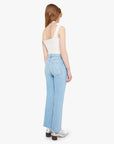 Woman wearing light blue jeans and a white top on a white background