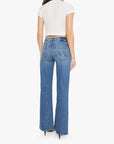 A woman viewed from the back wearing a white cropped short-sleeve top and blue wide-leg jeans with a distinctive W-shaped pocket on the back, set against a plain white background.