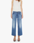 Woman wearing a white sleeveless top and blue jeans on a white background
