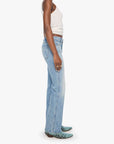 Woman wearing light blue jeans and a white top on a white background