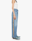 Woman wearing light blue jeans with a decorative side panel on a white background