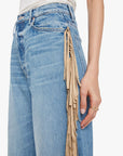 Blue jeans with fringe detail on a white background