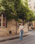 Woman wearing The Tommy Low Slung Straight standing on a street in an urban setting with trees and building