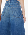 Blue jeans worn by a person on a white background