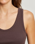 Close-up of a person wearing a brown tank top against a neutral background close up detail view