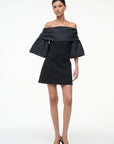 Black off-shoulder dress worn by a model on a white background, front