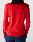 Person wearing a red long-sleeve shirt and blue jeans on a white background