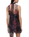 A sleeveless sheer mesh dress with an abstract brushstroke pattern in red, purple, and blue over a black base, shown from the back on a model against a white background.