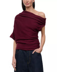model wearing off shoulder pinot sweater with jeans on a white background
