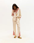 Person wearing a cream and pink outfit on a white background