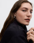 Close-up of a person wearing a black jacket against a plain background