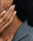 Close-up of a person wearing Tiger Eye Lyra Earrings