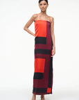 Model wearing a colorful geometric-patterned dress on a white background