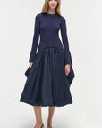 Woman wearing a navy blue dress with a white background front