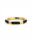 A gold-plated bangle bracelet with alternating black enamel segments, shown on a clean white background.