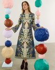 model wearing a print dress with art balls around her and a white background