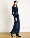 Woman wearing a navy blue dress with a belt in a minimalistic setting