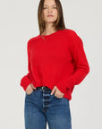 Person wearing a red sweater and blue jeans on a plain background