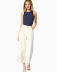 model wearing a high neck lace trim tank with white bottoms on a white background