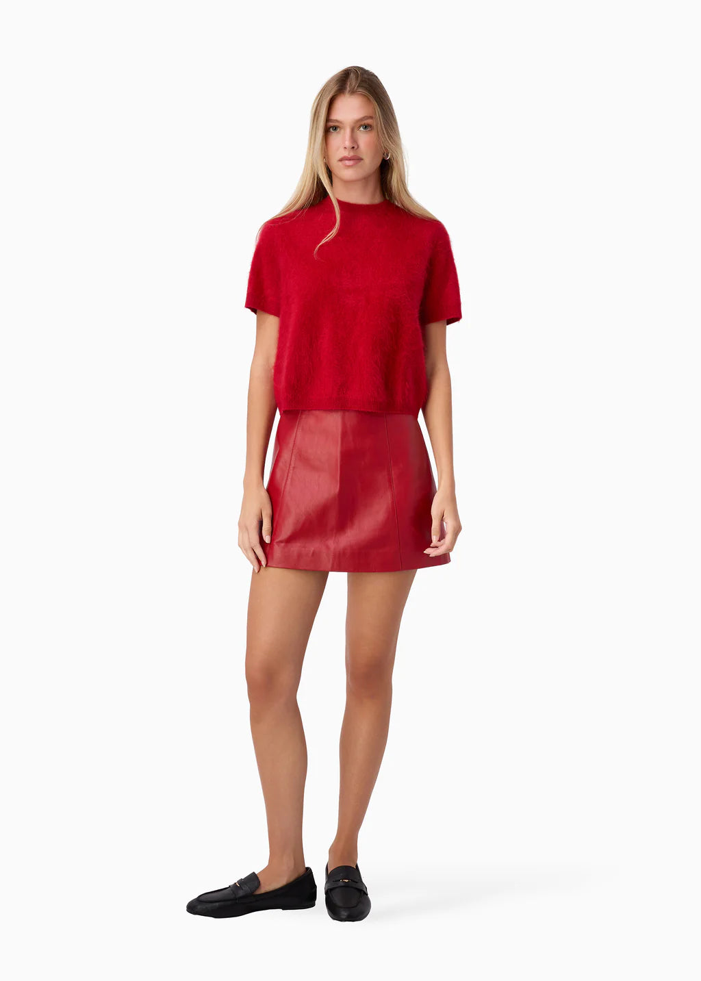 Woman wearing a red t-shirt and red leather skirt on a white background