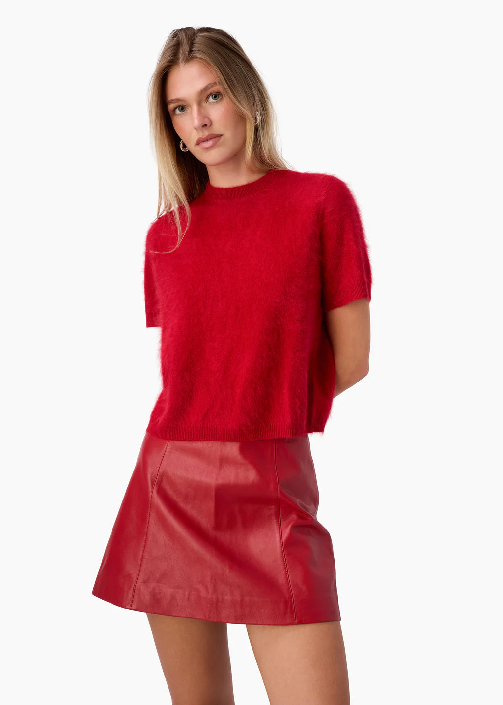 Woman wearing a red sweater and red skirt on a white background