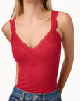 Red lace-trimmed tank top worn by a person on a white background