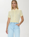 Woman wearing a light yellow blouse and light blue jeans on a white background