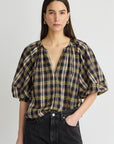 model wearing a plaid vneck short sleeve top with black on a grey background