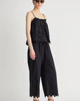 Woman wearing a black lace jumpsuit on a white background