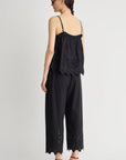 Woman wearing a black lace-trimmed jumpsuit on a white background