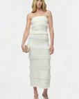 Woman wearing a strapless white dress on a white background