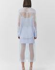 Person wearing a sheer blue outfit on a white background