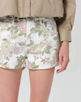 Person wearing floral shorts with a neutral background