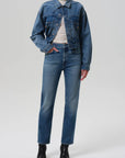 Person wearing a blue denim jacket and jeans on a white background front view