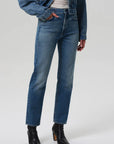 Person wearing blue jeans and a denim jacket on a white background