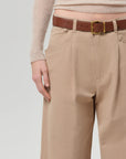 Beige pants with a brown belt on a plain background