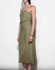 Woman wearing an olive green dress against a white background